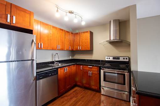 A modern kitchen with wooden cabinets and stainless steel appliances.