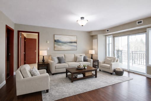 A living room with a white couch, a coffee table, and a painting on the wall.