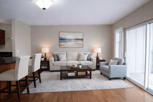A living room with a grey couch, a coffee table, and a painting on the wall.
