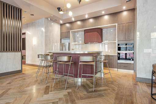 A modern kitchen with a wooden floor and a central island at The Woods at 180 Kanata Avenue Apartments, Kanata, Ontario