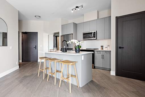A kitchen with a bar stool and a counter at The Woods at 180 Kanata Avenue Apartments, Ontario