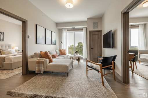 A living room with a white couch and a wooden chair.