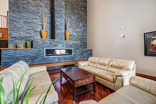 a living room with leather furniture and a fireplace