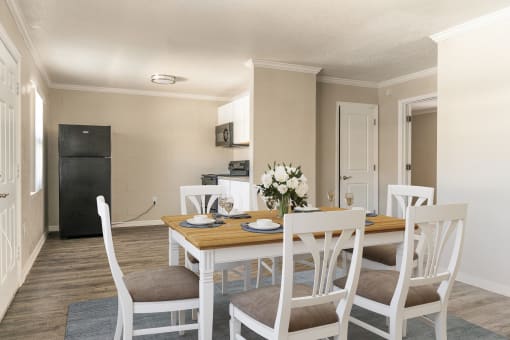 a dining room with a table and chairs and a kitchen in the background  at North Washington Apartments