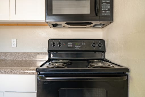 stovetop and microwave in kitchen at North Washington Apartments