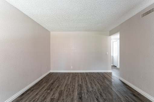 A room with wooden flooring and white walls.