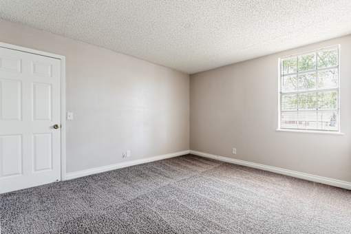 A room with a white door and a window with blinds.