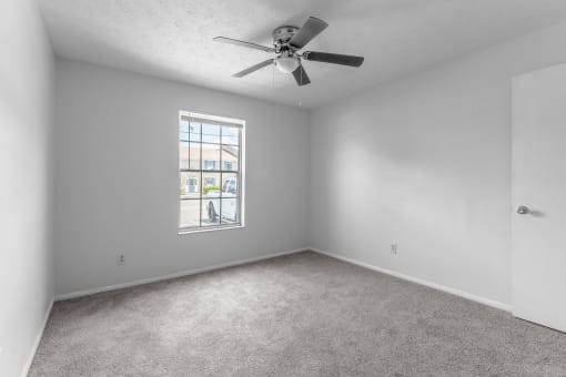 bedroom with a ceiling fan and a window at Jacksonville Heights Apartments