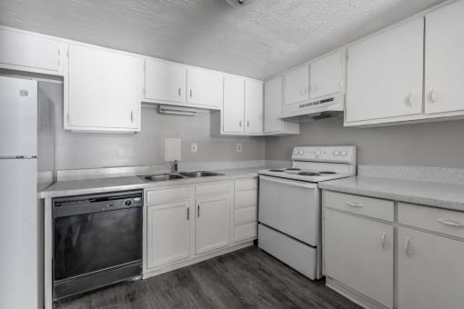 kitchen with white cabinets and appliances at Jacksonville Heights Apartments