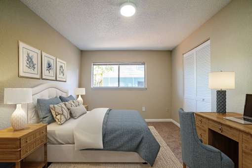 A bedroom with a bed, desk, and chair.