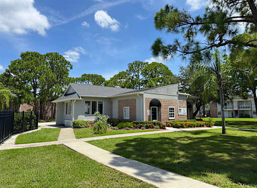 A house with a white fence and a green lawn.