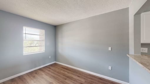 a dining room with hardwood floors and grey walls