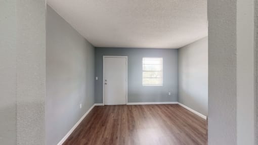 an empty room with hardwood floors and a white door