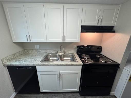 A kitchen with black appliances and white cabinets.