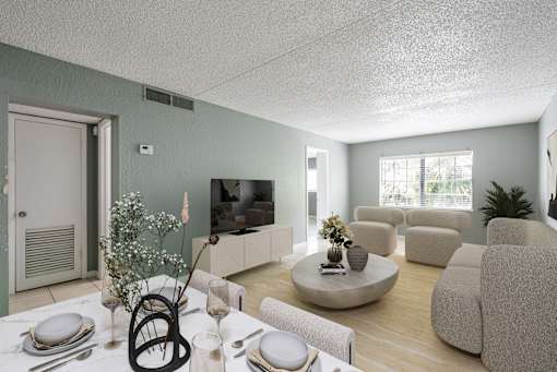 A living room with a dining table set for two and a television.
