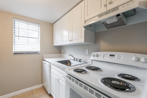 a kitchen with white cabinets and a white stove top oven at Del Rio Apartment