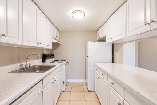 a kitchen with white cabinets and white countertops at Del Rio Apartment