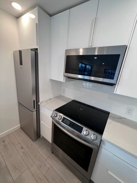 a kitchen with a stove a refrigerator and a microwave