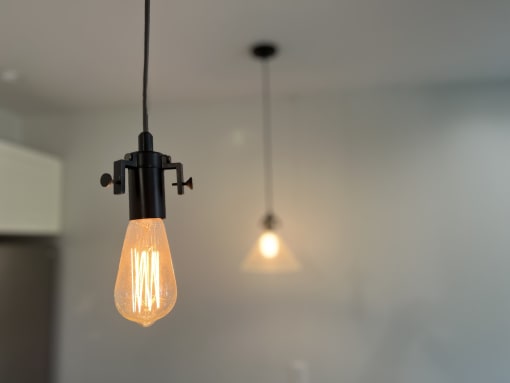 a black pendant lamp and a white pendant light hanging from a ceiling