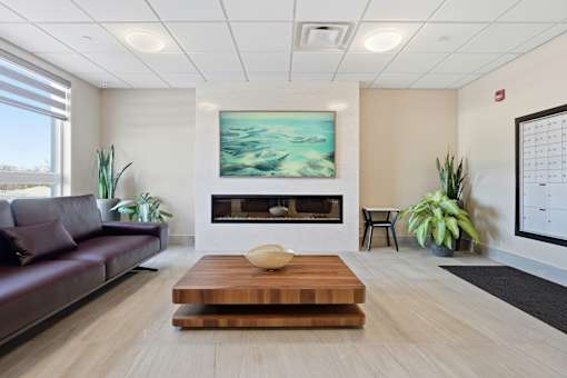 A modern living room with a fireplace and a painting on the wall.