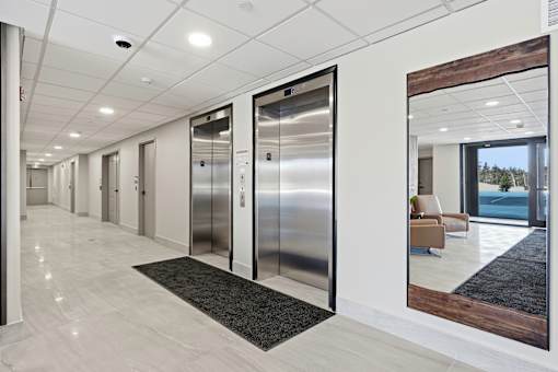 A hallway with a row of elevators on the right side.