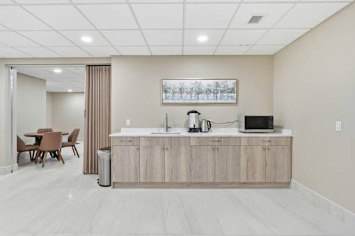 A kitchen with a wooden counter and a fridge.