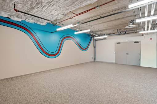 A large empty room with a blue and red wave design on the wall.