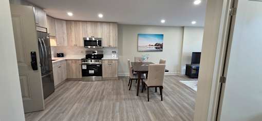 A kitchen with a dining table and chairs.