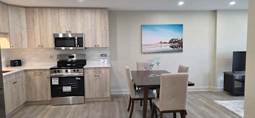 A kitchen with a dining table and chairs.