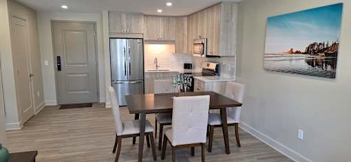 A dining room with a wooden table and chairs.