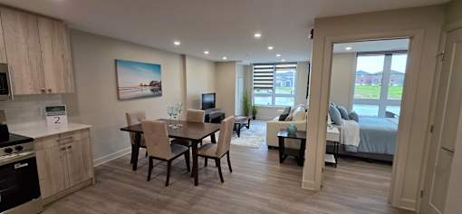 A well-lit, spacious apartment with a kitchen, dining area, and a bedroom with a balcony.