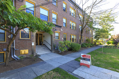 a brick building with a red ``for lease' sign in front of it