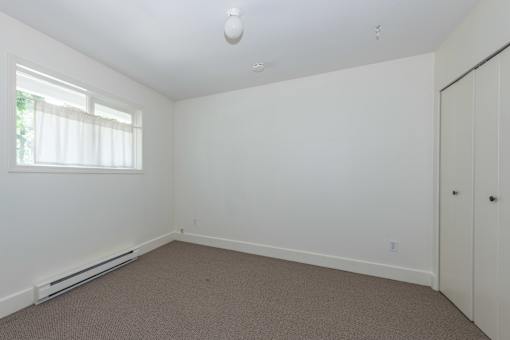 a bedroom with white walls and carpet