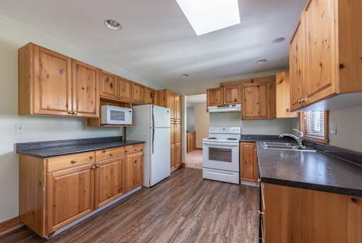 a kitchen with wood cabinets and black countertops