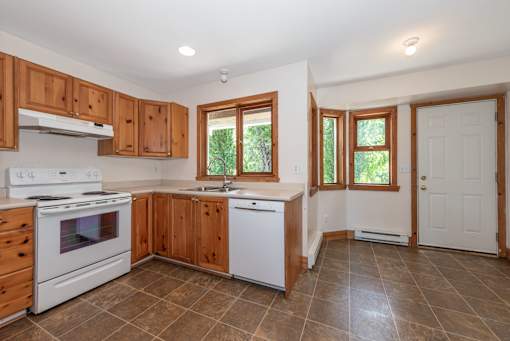 a kitchen with white appliances and wooden cabinets
