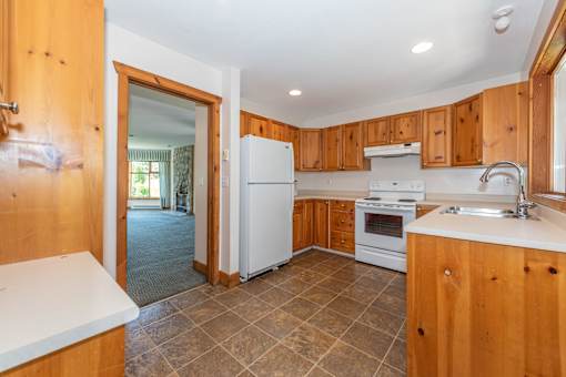 a kitchen with white appliances and wooden cabinets