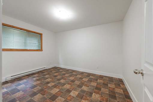 an empty room with a window and a door