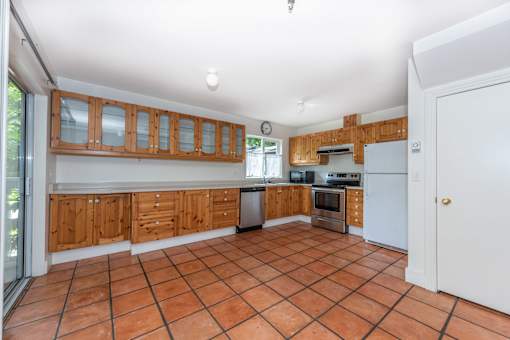 a kitchen with wooden cabinets and a tiled floor