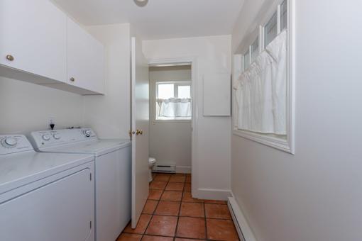 a laundry room with white cabinets and a white washer and dryer