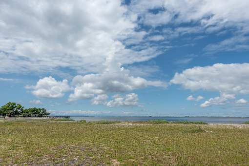 a grassy field with a body of water in the background