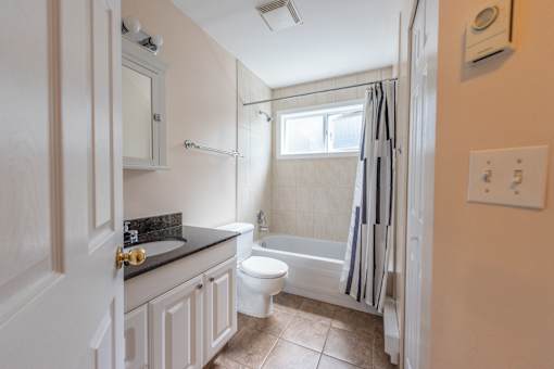 a bathroom with a white toilet next to a white bath tub