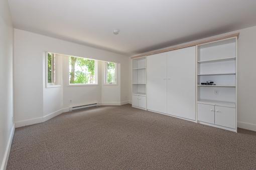 a bedroom with white walls and carpet