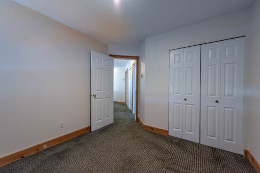 a bedroom with two doors and a carpeted floor