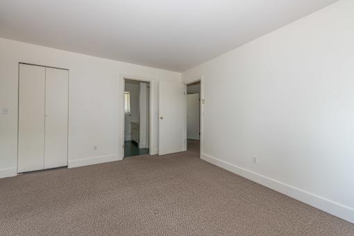 a bedroom with white walls and carpet
