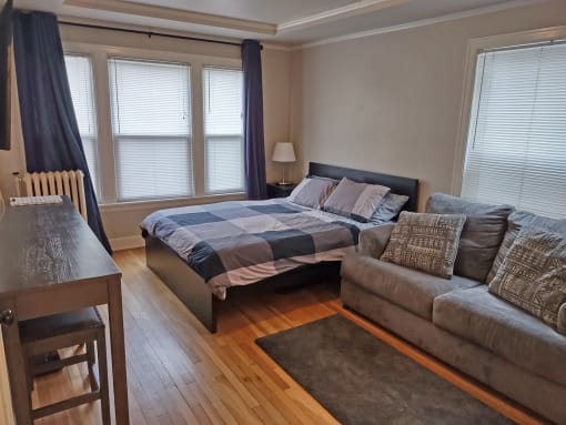 a bedroom with a bed and a couch and a table