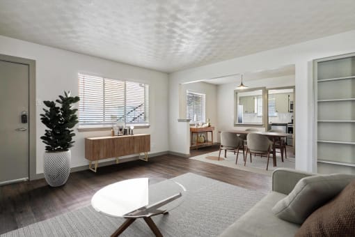 a living room with a couch and a coffee table and a dining room and kitchen