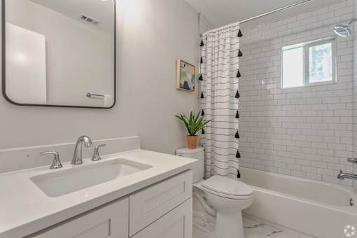 A white bathroom with a sink, toilet, and bathtub.