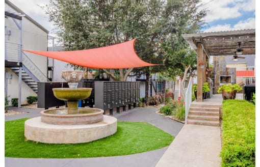 a courtyard with a red canopy and a fountain at Cityscape, Dallas, TX