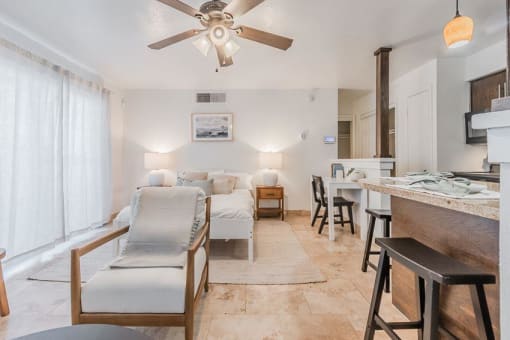 a living room with a couch and a kitchen and a ceiling fan at Cityscape, Dallas, TX