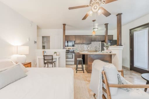 a living room and kitchen with a bed and a ceiling fan at Cityscape, Dallas, TX